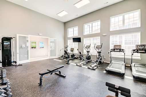 A spacious gym with a variety of equipment including treadmills, weights, and exercise machines.