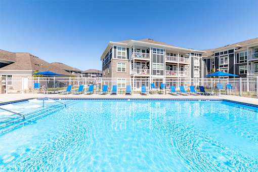 A large swimming pool in front of a resort building.