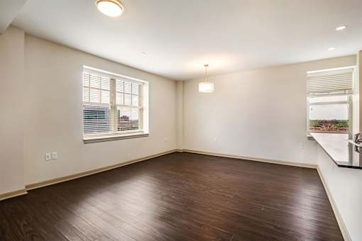 A room with wooden flooring and a window with blinds.
