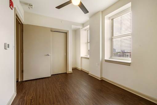A room with a brown door and a ceiling fan.