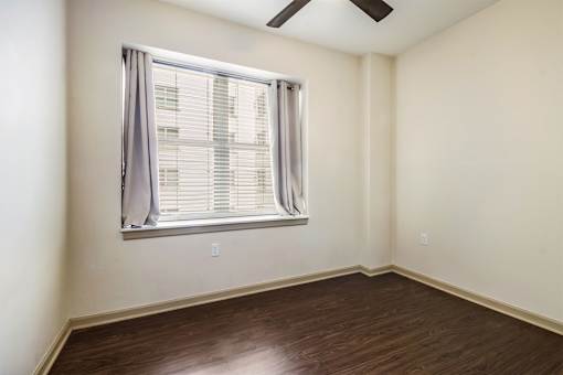 A room with a window and a ceiling fan.