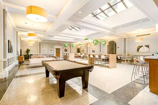 A spacious room with a pool table in the center.