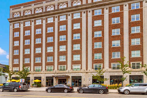 A large red brick building with a parking lot in front.
