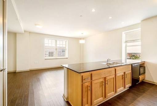 A kitchen with wooden cabinets and a black countertop.