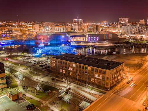 A cityscape at night with a large building in the foreground.
