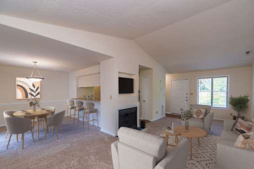 A living room with a fireplace and a dining table.