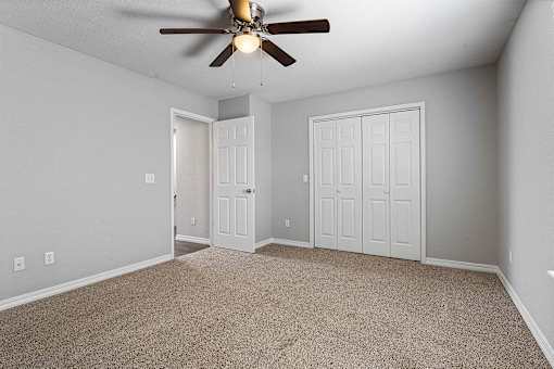 A room with a ceiling fan and two doors.