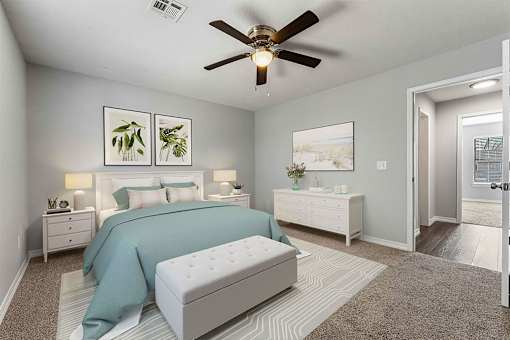 A bedroom with a bed, nightstand, and a ceiling fan.