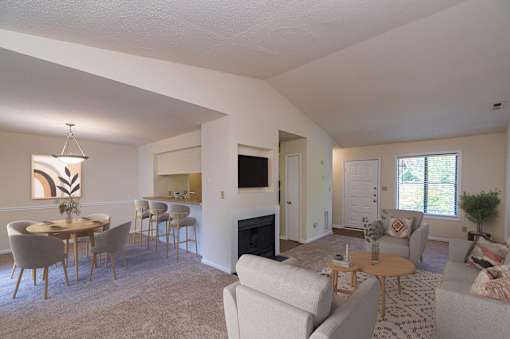 A living room with a fireplace and a dining table.