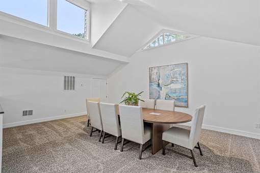 A dining room with a round table and chairs.
