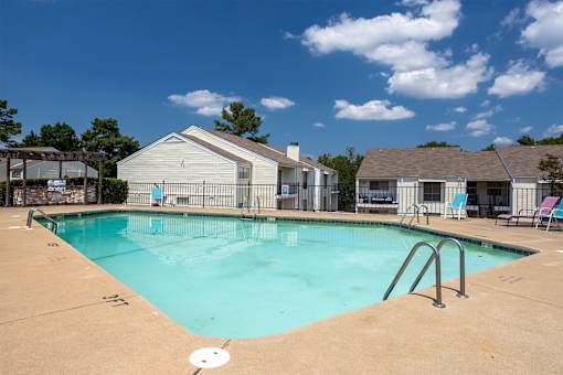 A swimming pool with a slide and a house in the background.