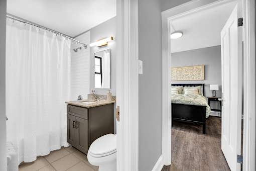 A bathroom with a toilet, sink, and shower curtain.