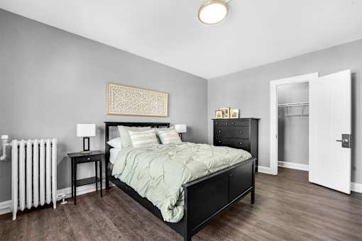 A bedroom with a bed, nightstand, and lamp.