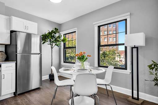 A modern kitchen with a dining table set for two.