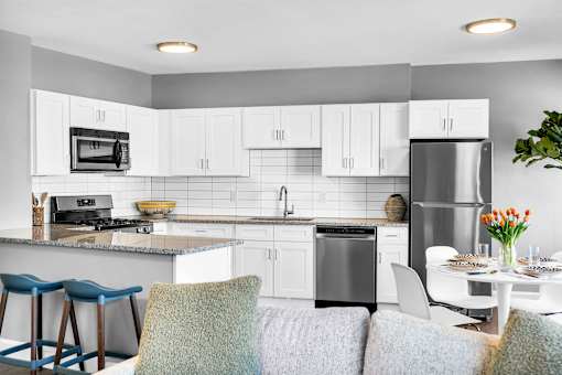 A modern kitchen with a dining table set for two.