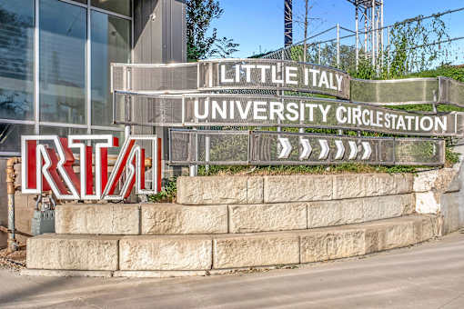 A sign for Little Italy University Circus Station is displayed in front of a building.
