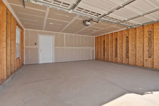 a room with a concrete floor and wooden walls and a white door