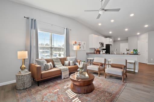 a living room with couches and chairs and a ceiling fan