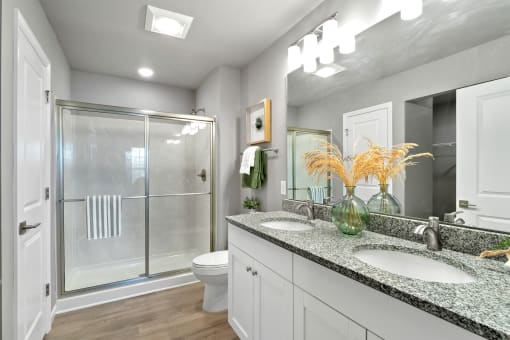 a bathroom with two sinks and a shower and a toilet