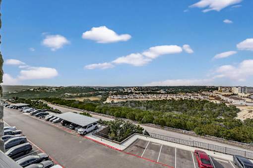 A parking lot with cars and a building in the distance.