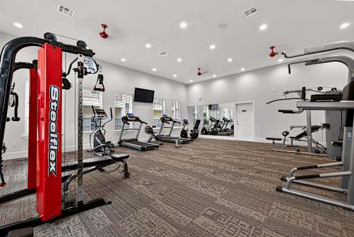 A gym with a red XFERREX machine in the foreground.