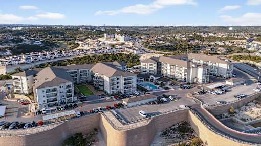 A large building complex with a parking lot in front.