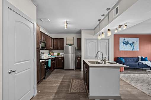 A kitchen with a white door and a white sink.