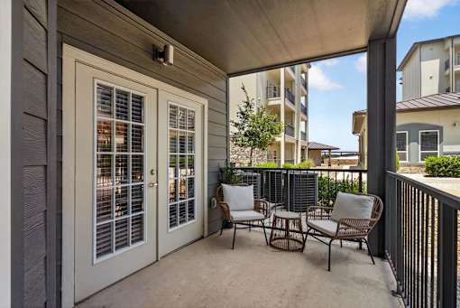 A patio with a table and chairs is covered by a roof.