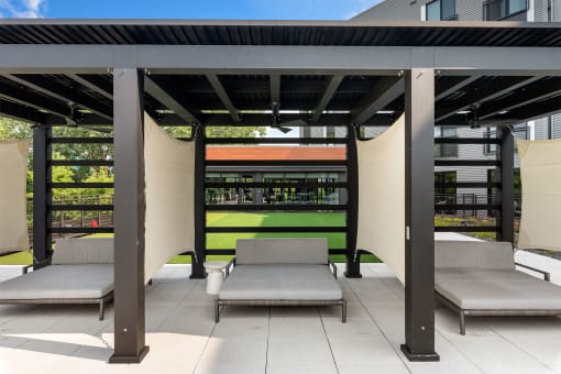 a pergola with two chaise lounges on a patio