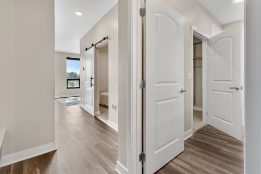 a bedroom with white doors and hardwood floors
