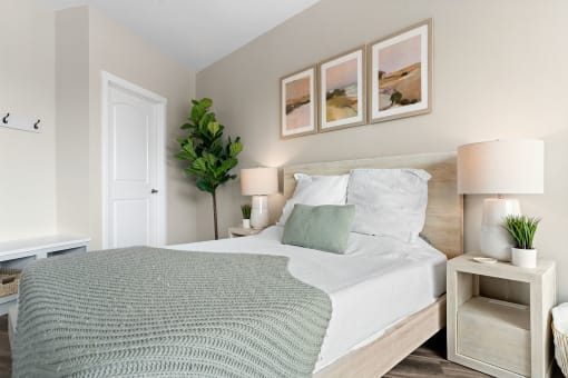a bedroom with a bed and three paintings on the wall