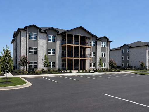 A large, modern apartment complex with a parking lot in front.