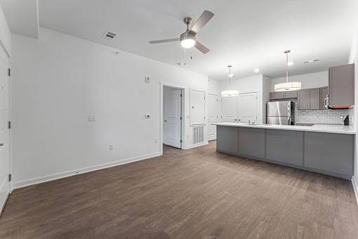 A spacious kitchen with a fan and a dining area.
