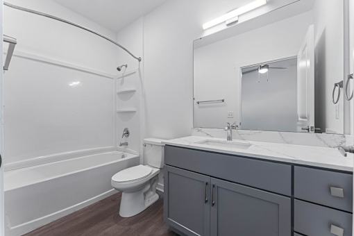 A white bathroom with a toilet, sink, and bathtub.