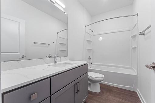 A white bathroom with a toilet, sink, and bathtub.