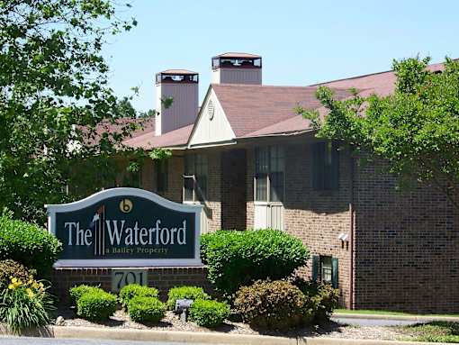 A brick building with a sign that says The Waterford in front of it.