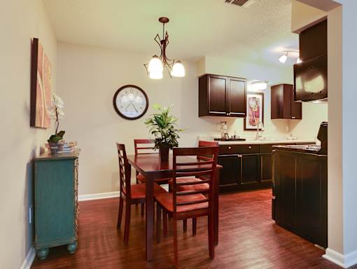 A kitchen with a table and chairs.