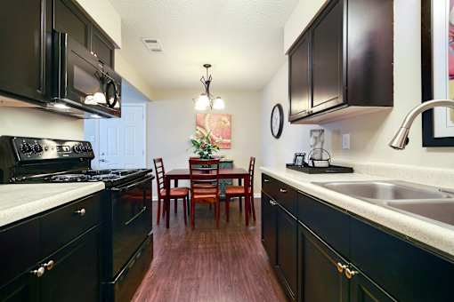 A kitchen with dark wood cabinets and a white countertop.