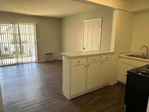 an empty kitchen with white cabinets and a sink