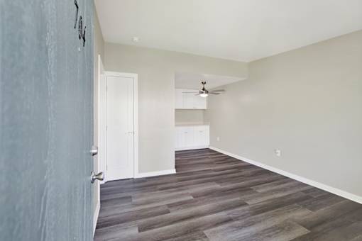 A room with a wooden floor and a ceiling fan.