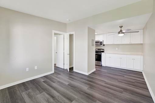 A room with a kitchen area in the background.