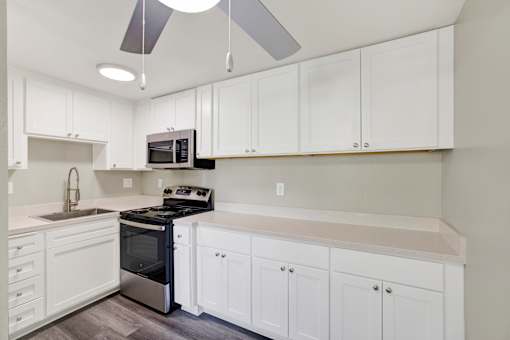 A kitchen with white cabinets and a black stove top oven.