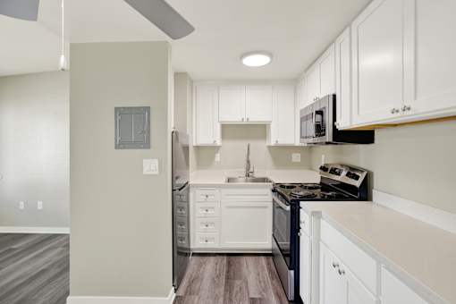 A kitchen with white cabinets and a black stove top oven.