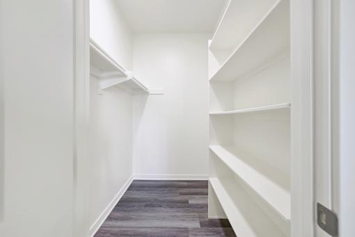 A long hallway with white shelves on the side.
