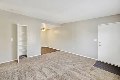 A room with a carpeted floor and a white door.