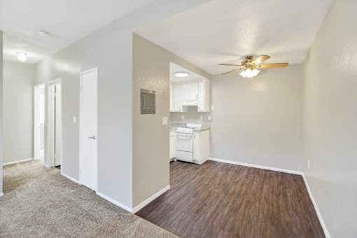 A room with a ceiling fan and a wood floor.