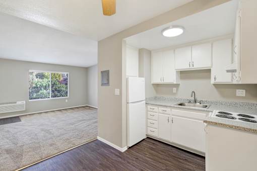 A kitchen with white cabinets and a white fridge.