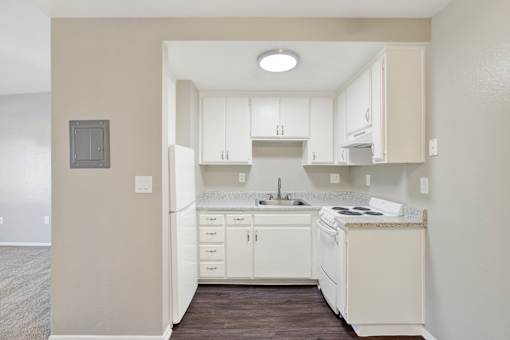 A kitchen with white cabinets and appliances.