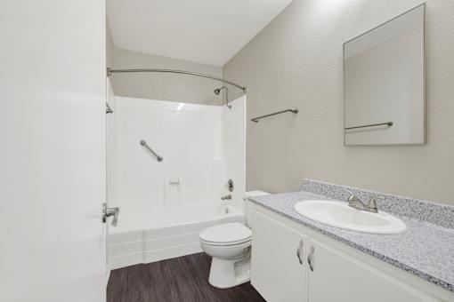 A white bathroom with a toilet, sink, and shower.