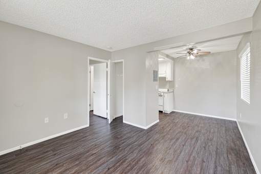 A room with wood flooring and a ceiling fan.